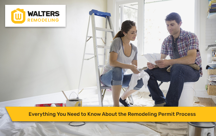 Two people reviewing permit documents during a home remodeling project